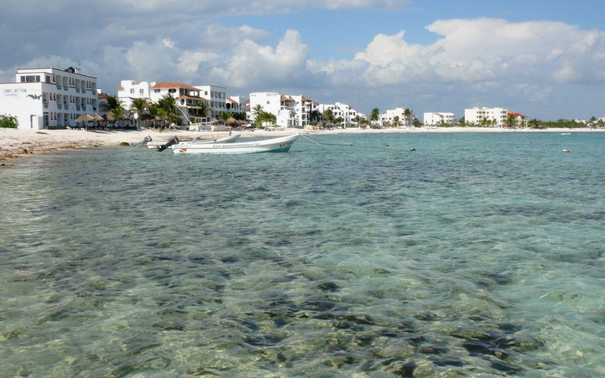 Rocky cove with calm turquoise water and low limestone rocks at Akumal Half Moon Bay, Mexico